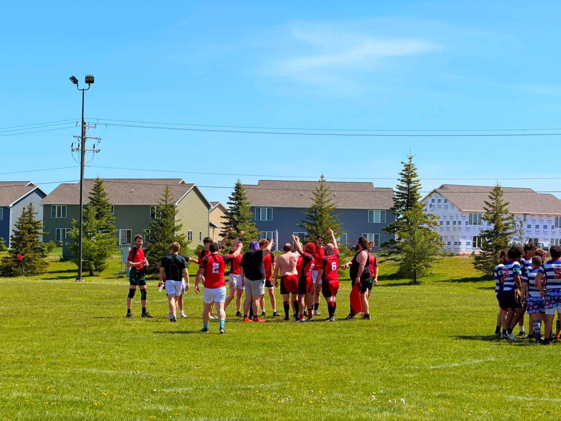 Escanaba Berserkers team huddle in red kits before kickoff